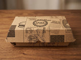 Gesloten kraft hamburgerdoos met krantenprint op een houten tafel